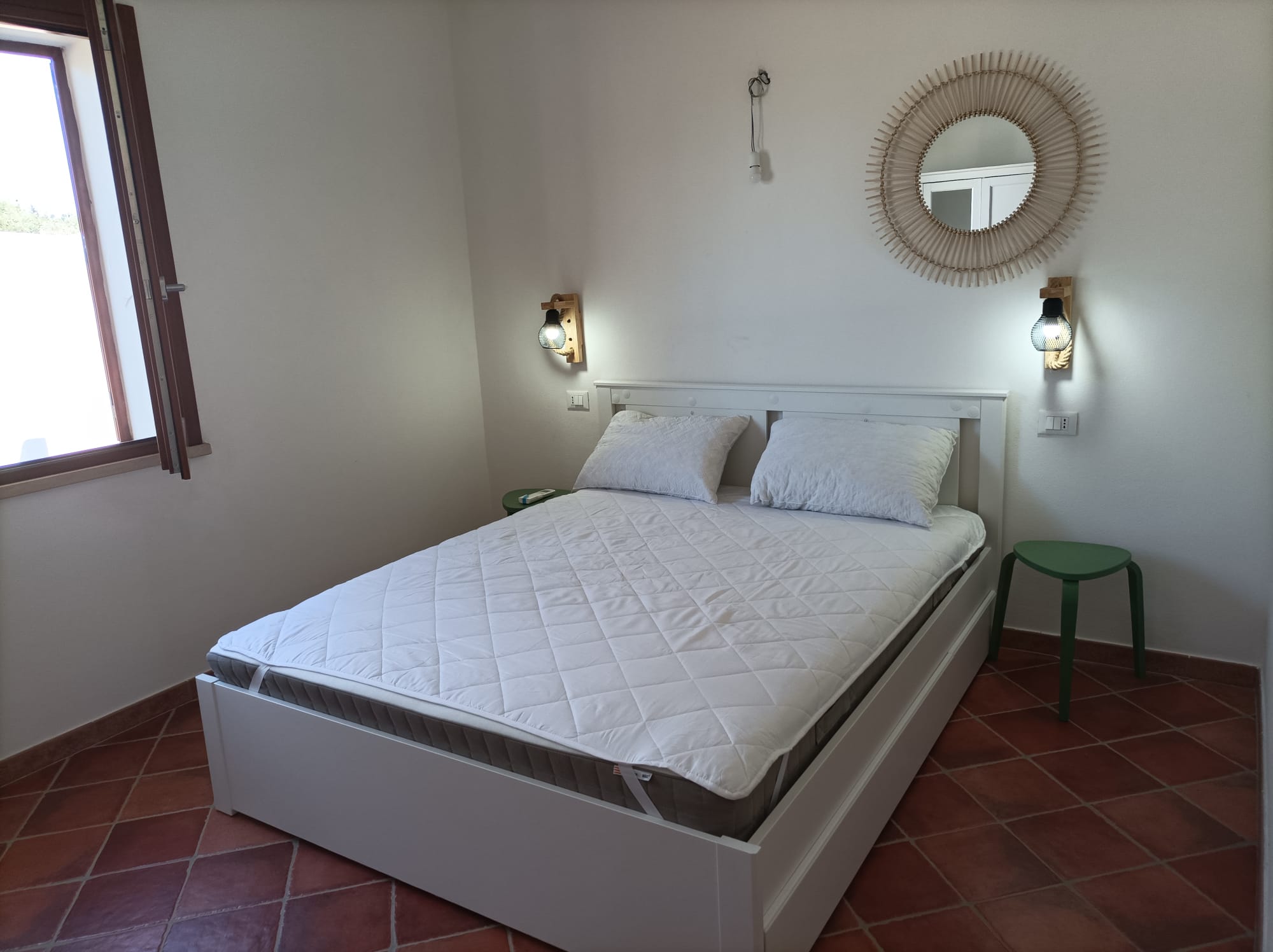 Arredamento curato della camera matrimoniale con specchio in rattan