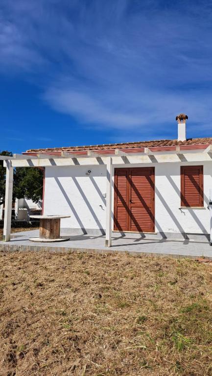 Esterno della casa vacanze con pergola in legno e architettura mediterranea